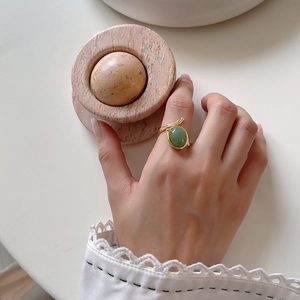 Detailed view of vintage gold ring featuring a green oval stone and textured band