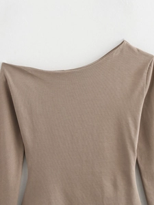 Close-up of khaki knit top featuring asymmetric off-shoulder neckline and fine stitching