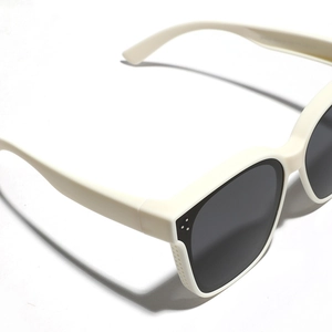 Fashion polarized sunglasses in off-white frame with dark lenses from a side angle