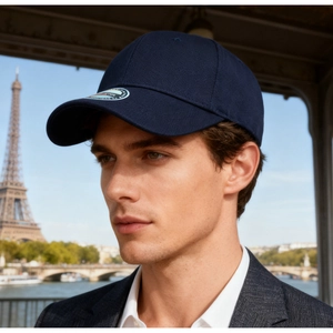 Close-up of navy blue baseball cap worn by model with Eiffel Tower backdrop