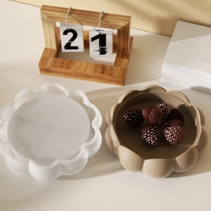 Detail of scalloped petal resin mold and matte finished decorative tray with pine cone