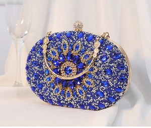 Detailansicht der luxuriösen königsblauen Abendtasche mit Kristallen und Goldgriff