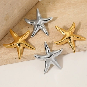 Starfish shaped earrings in gold and silver finish on a natural textured stone plate