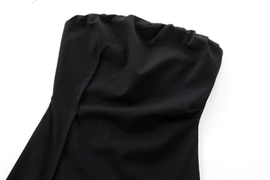 Close-up of black tube dress fabric texture with pleated strapless neckline detail