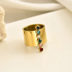 Macro shot of wide gold ring with vertical multi-color zircon stones and polished finish