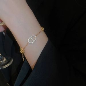 Close-up of gold plated chain bracelet with a sparkling crystal oval clasp on a wrist