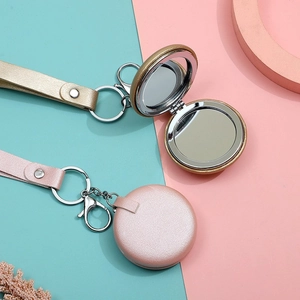 Detail of pink and gold folding makeup mirrors with leather texture and wrist strap