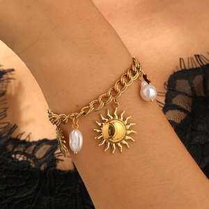 Gold vintage sun pendant bracelet with pearls on a model wearing black lace clothing