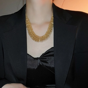Close-up of golden spike necklace on neck showing avant-garde metallic texture