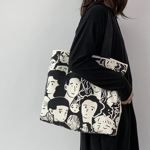 Detail of canvas tote bag with portrait illustration worn by model in black dress