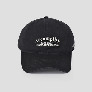 Detail of black cotton baseball cap featuring white Accomplish embroidery and curved brim