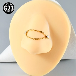 Detail of G23 titanium gold nose chain with white zircon studs on a silicone model