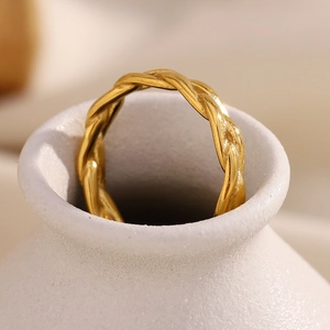 Detailed view of 18K gold plated braided ring resting on a white ceramic bottle neck