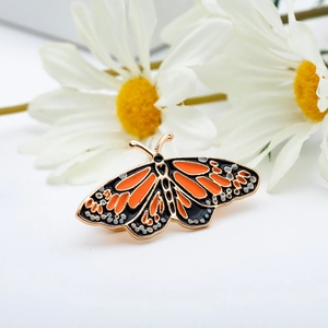 Spilla creativa a farfalla in smalto arancione e nero con cornice in lega dorata