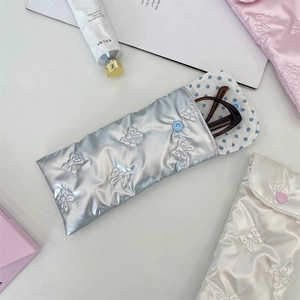 Detailed view of silver bow quilted glasses pouch with blue polka dot lining and snap button