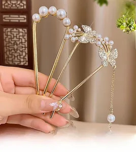 Détail d'épingles à cheveux dorées avec pompons papillon et perles dans un style vintage