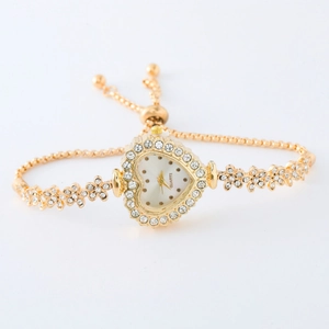 Close-up of heart-shaped gold quartz watch with rhinestones and adjustable slider bracelet