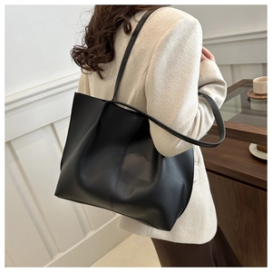 Detailed back view of a large black faux leather tote bag with elegant vertical stitching