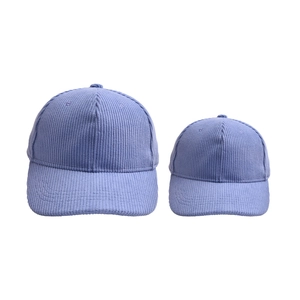 Matching set of two blue-purple corduroy baseball caps for parent and child shown on white