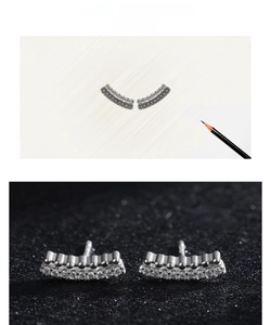 Macro shot of curved geometric s925 silver stud earrings with pavé zircon and metallic beads