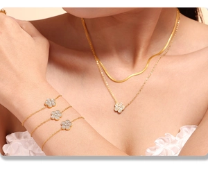 Detail of gold clover necklace and bracelet set with pave zircon stones on model