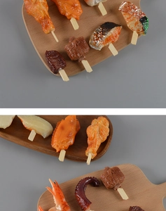 Detailweergave van PVC BBQ-spiesmodellen met vleugels, garnalen en vlees op houten schalen
