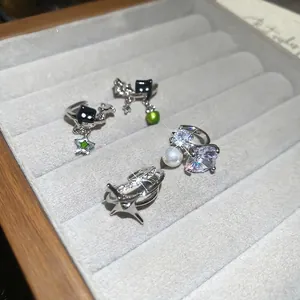 Sparkling zircon star ear clips set with black cat motifs and green drips on silver metal
