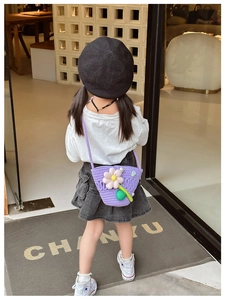 Detail view of purple knitted toddler crossbody bag with 3D floral accent on a model
