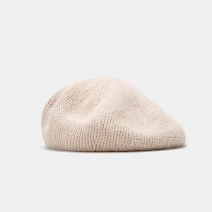 Gros plan du béret tricoté beige avec paillettes subtiles et texture en laine douce