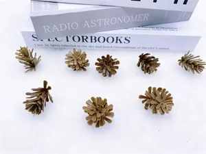 Lot de huit pommes de pin artificielles marron foncé sur une surface en peluche blanche
