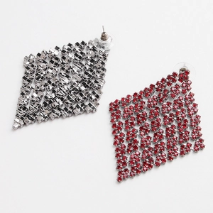 Close-up of geometric rhombus earrings featuring vibrant red rhinestones and silver backing