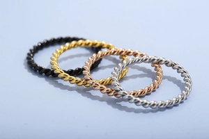 Detailed view of twisted rope bands in black, gold, rose gold and silver stainless steel