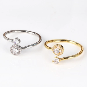 Detailed macro view of adjustable silver and gold zircon rings on white background