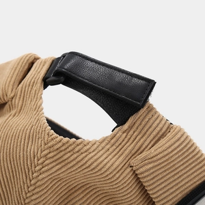 Détail du tissu en velours côtelé kaki et sangle réglable en cuir sur le bonnet