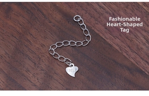 Macro view of S925 sterling silver extender chain with a heart-shaped engraved tag