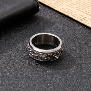 Vintage titanium steel men's ring with embossed floral patterns on a leather background