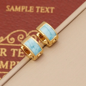 Macro view of gold stainless steel earrings with sky blue enamel marble texture