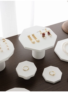 Makroaufnahme von Goldschmuck mit Perlen auf weißen geometrischen Gips-Displays