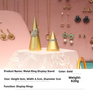 Macro shot of gold metal cone-shaped ring display stands in two different heights