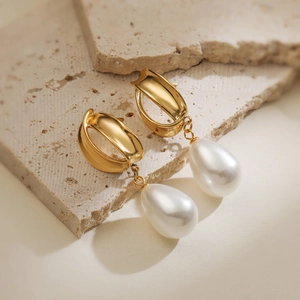 Orecchini di perle in acciaio placcato oro 18K presentati su pietra naturale