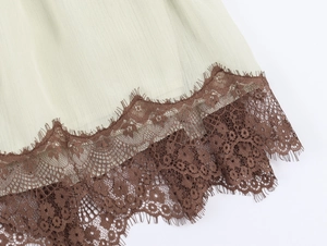 Detail of light green and brown patchwork dress with delicate eyelash lace trim
