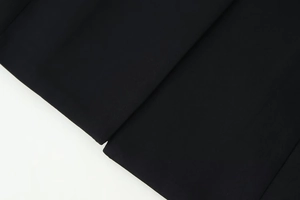 Detailed macro view of premium black plain weave fabric for fashionable V-neck blazers