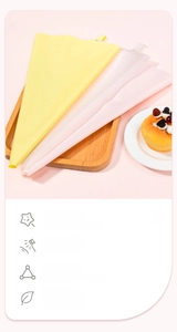 Detail of pink and yellow silicone pastry bags with wood tray and creamy desserts
