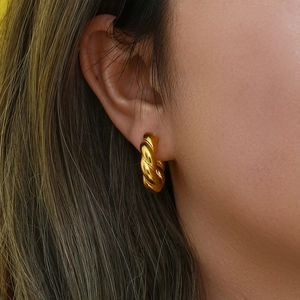 Macro detail of the twisted rope texture on an 18K gold-plated chunky hoop earring