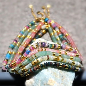 Vue macro d'un collier en perles de pierre colorées avec pendentif feuille doré