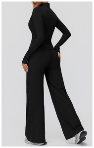 Side view of woman in black high-waisted wide-leg athletic pants and long sleeve top