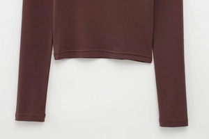 Detail of double-needle stitching on hem and cuffs of a dark brown long sleeve T-shirt