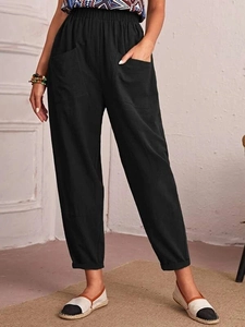 Detail of black cotton linen trousers showing elastic waist and large side pockets