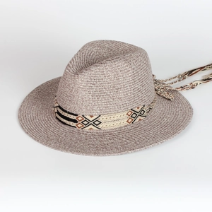 Detailed shot of woven straw fedora hat with ethnic geometric band and long tassels