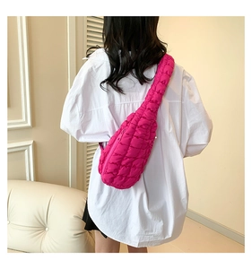 Détail du sac bandoulière matelassé rose vif avec texture rembourrée et fermeture éclair